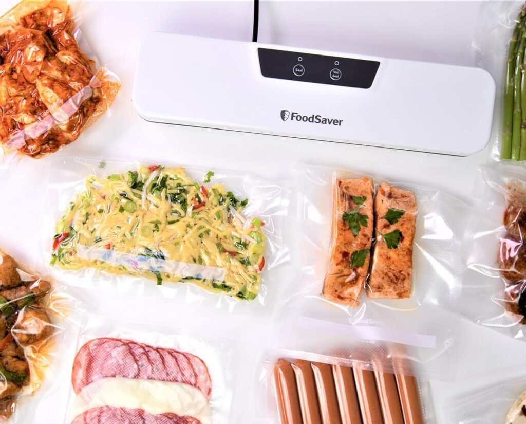 Selladora al vacío FoodSaver con alimentos sellados como salmón, vegetales, embutidos y espárragos.